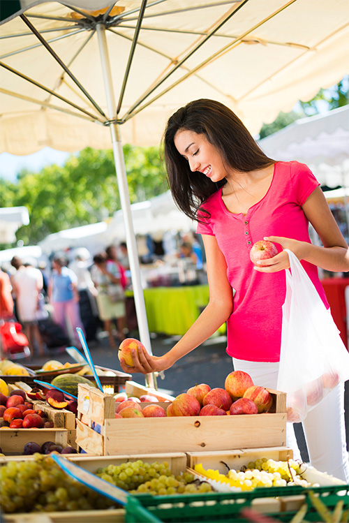 Woman buying apples at a healthy community event.