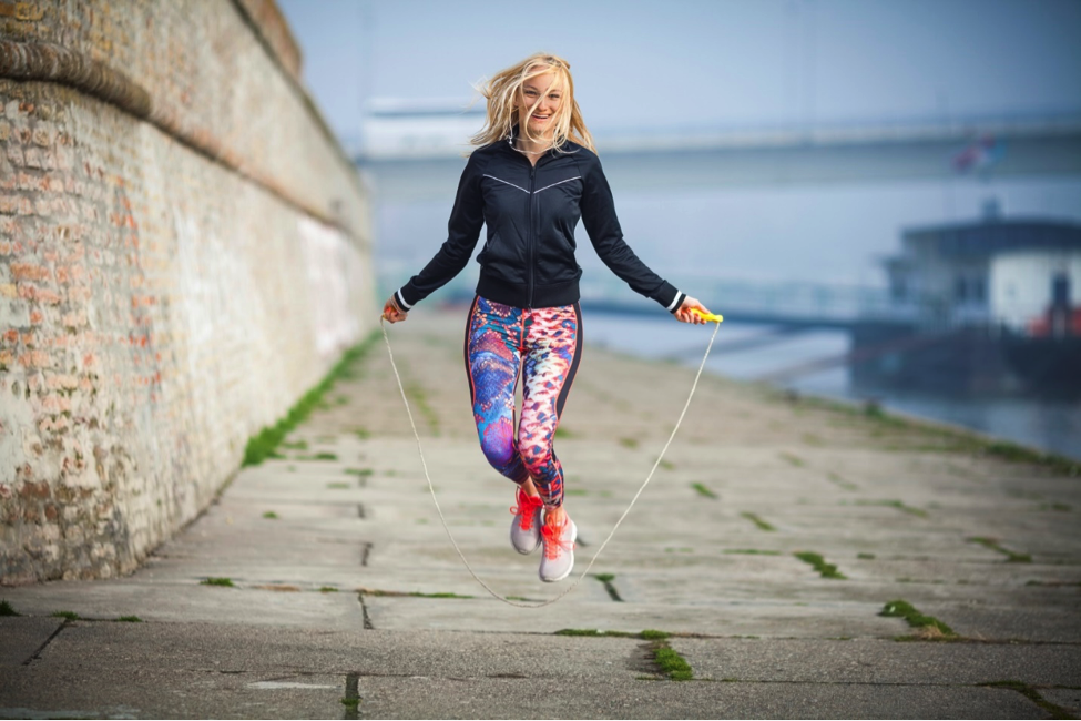 Young woman jump roping outdoors