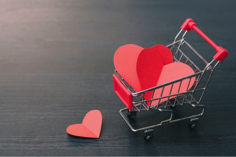 A mini shopping cart full of paper hearts.