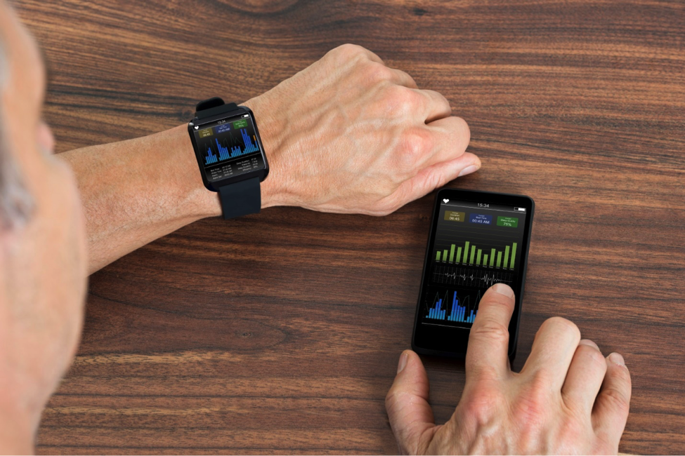 Man with a fitness tracker watch and a smart phone.