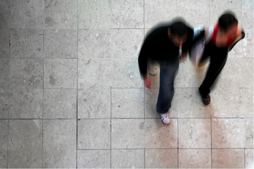 A man and woman walking indoors. 