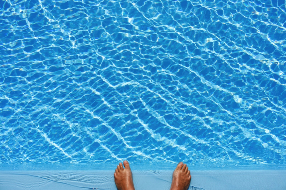 Two feet at the end of a swimming pool.