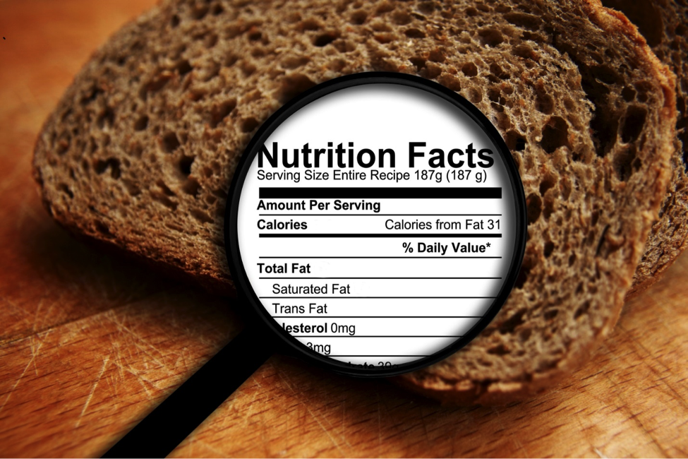 Magnifying glass showing nutrition label over bread.