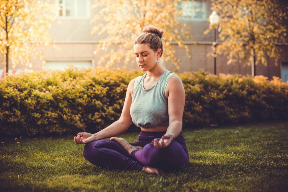 Woman sitting in yoga position to overcome stress-induced weight gain