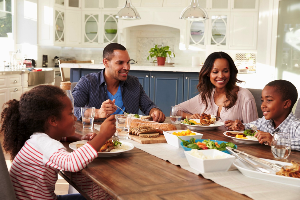 Family sitting at dining table for dinner.