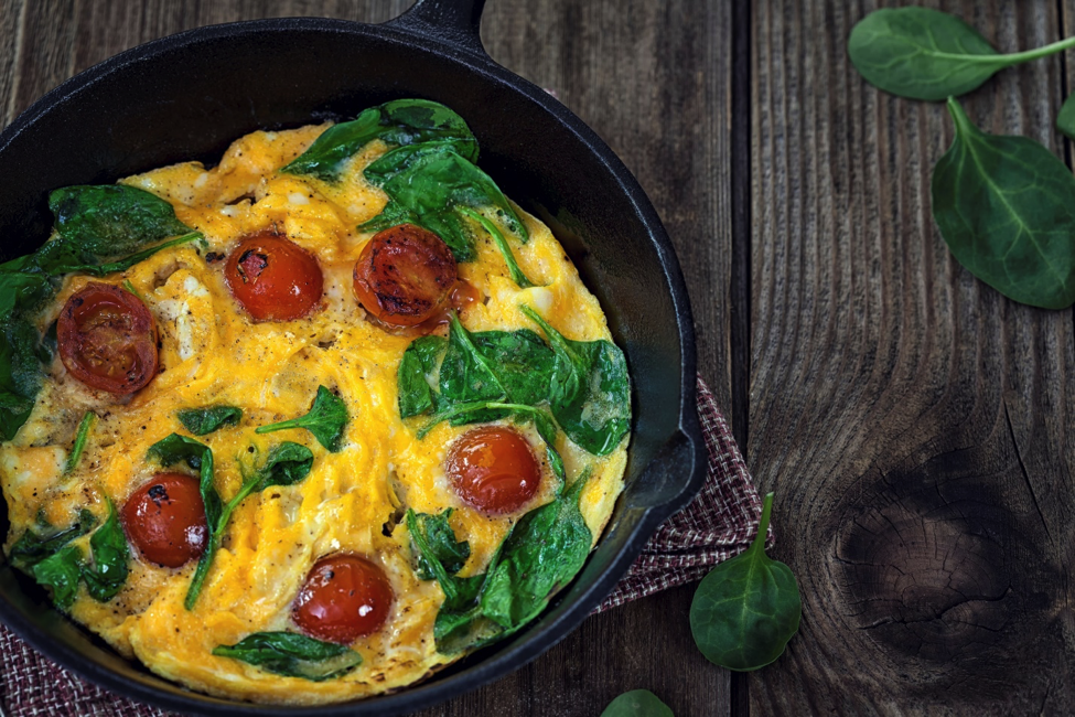 A high protein dish of eggs, spinach, and tomatoes.