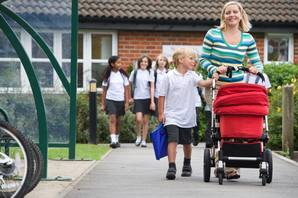 A parent on the go walking at a school for her back-to-school health.