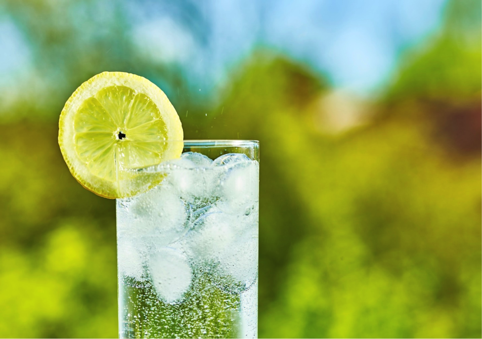Glass of sparkling water with lemon on the rim