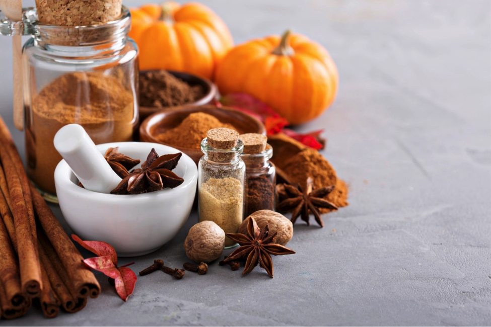 Fall spices and pumpkins arranged on table to make healthy recipes with pumpkin