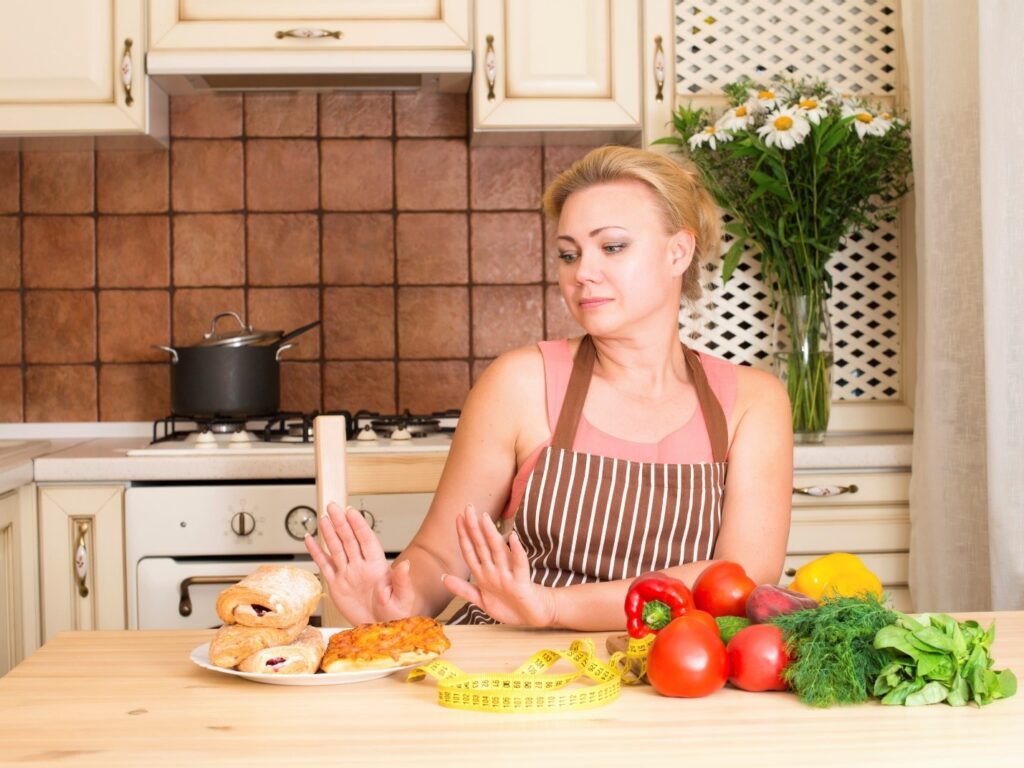 Woman choosing to eat vegetables over extra carbs for her post-Thanksgiving detox