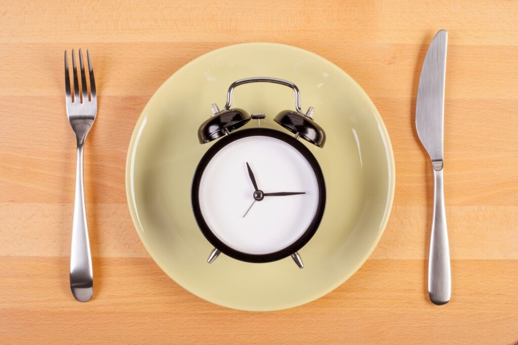 Clock sitting in the middle of a place setting