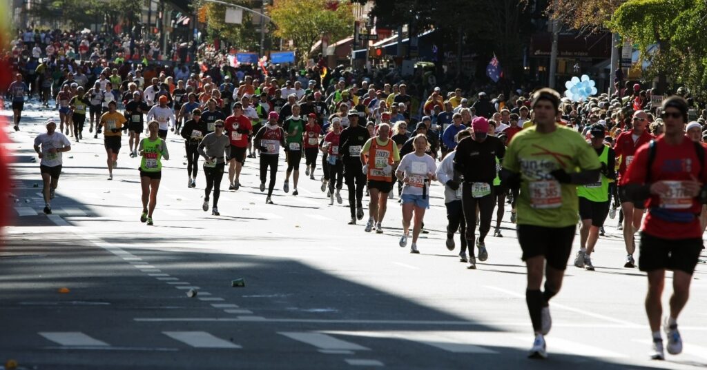 Large groups of marathon runners running through streets
