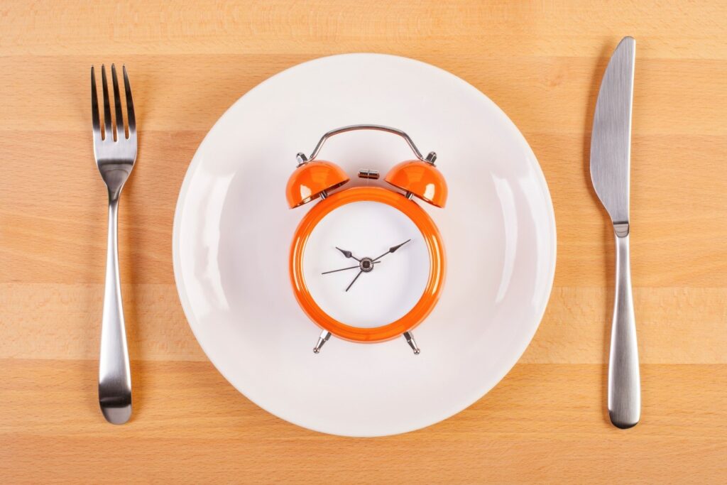 Clock on plate between silverware