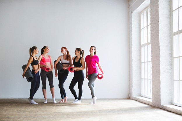 Fitness group of women doing yoga to establish workout accountability