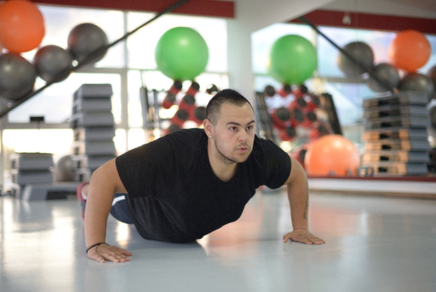 Young man doing push-ups at a San Antonio fitness center