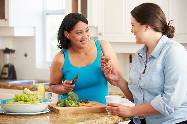 Two women with a healthy body image enjoying a snack together