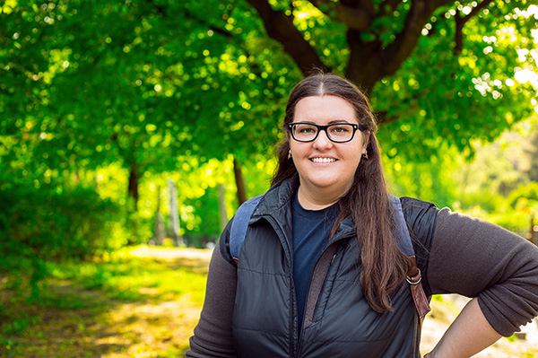 Plus-size young woman smiling while taking a walk outside.