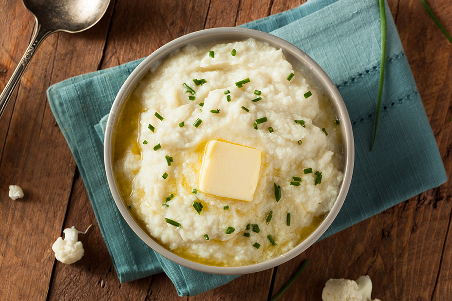 Bowl of mashed cauliflower on blue folded rag.