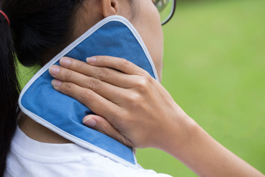 Woman holding cooling pad to neck as a way to stay cool in the heat.