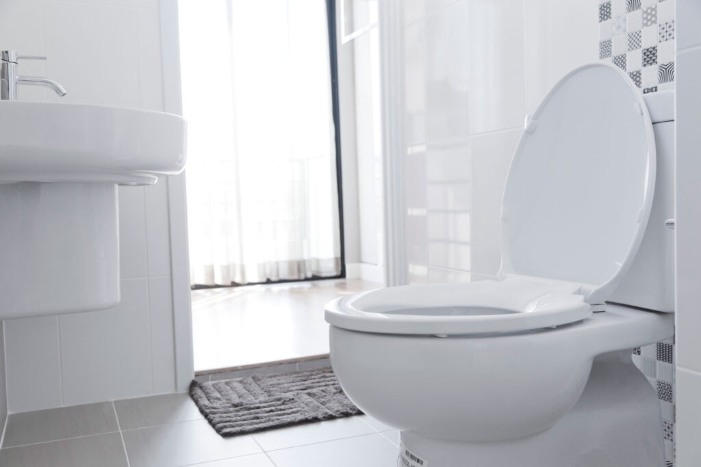 White bathroom with close up on a toilet with the lid up.