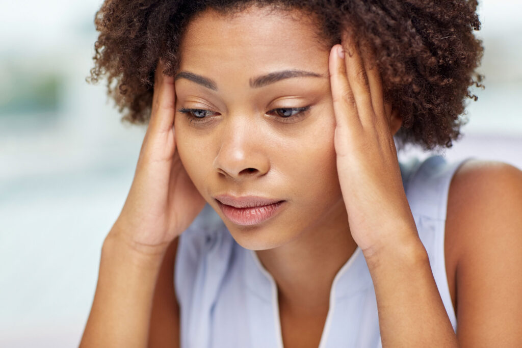 Woman holding sides of head to deal with headache.