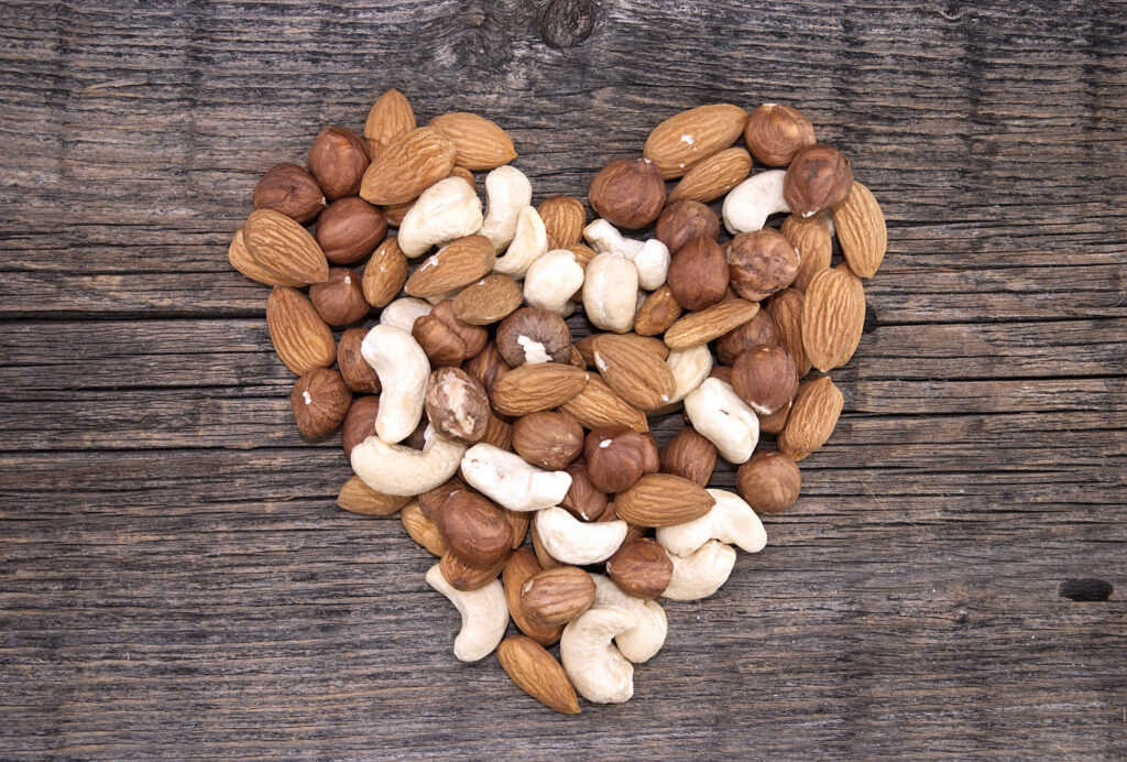 Best nuts to eat form a heart shape on a wooden background.