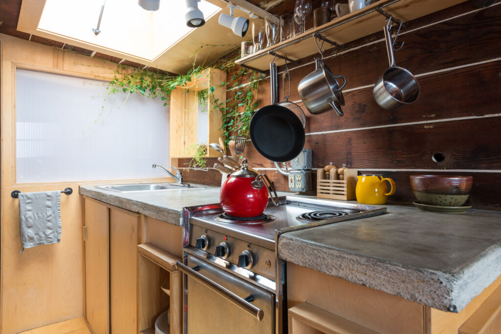 Cabin kitchenette with various pots and pans.