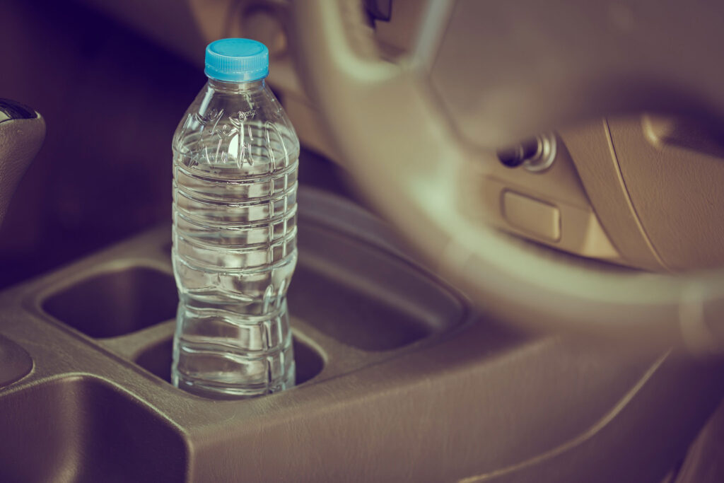 Close up of water bottle sitting in a car’s cup holder.