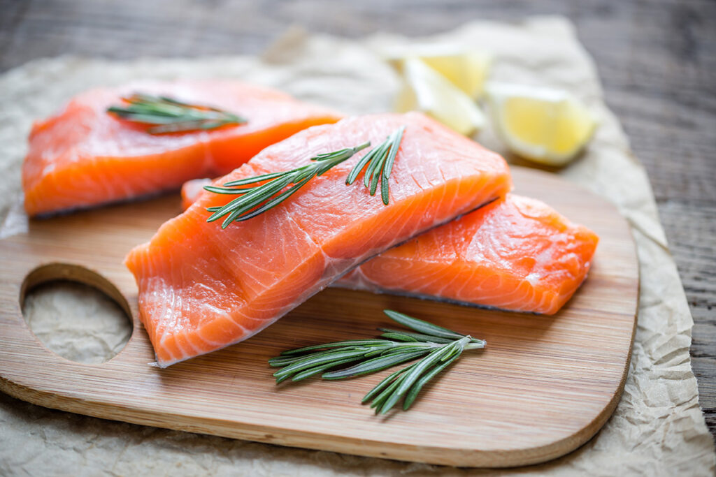 Salmon on cutting board with rosemary.