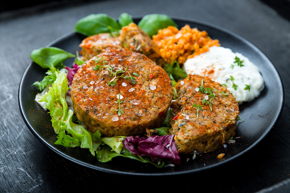 A gourmet plate of food with vegan patties and lettuce.