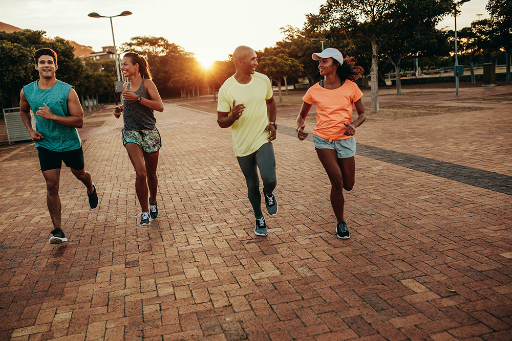 A group of four people running together to represent San Antonio fitness groups.