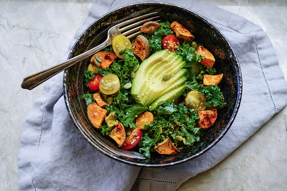 Bowl of avocado, lettuce and vegetables to represent paleo diet benefits.