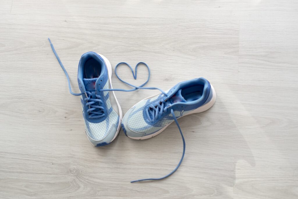 Blue and gray sneakers form the shape of a heart with the laces.