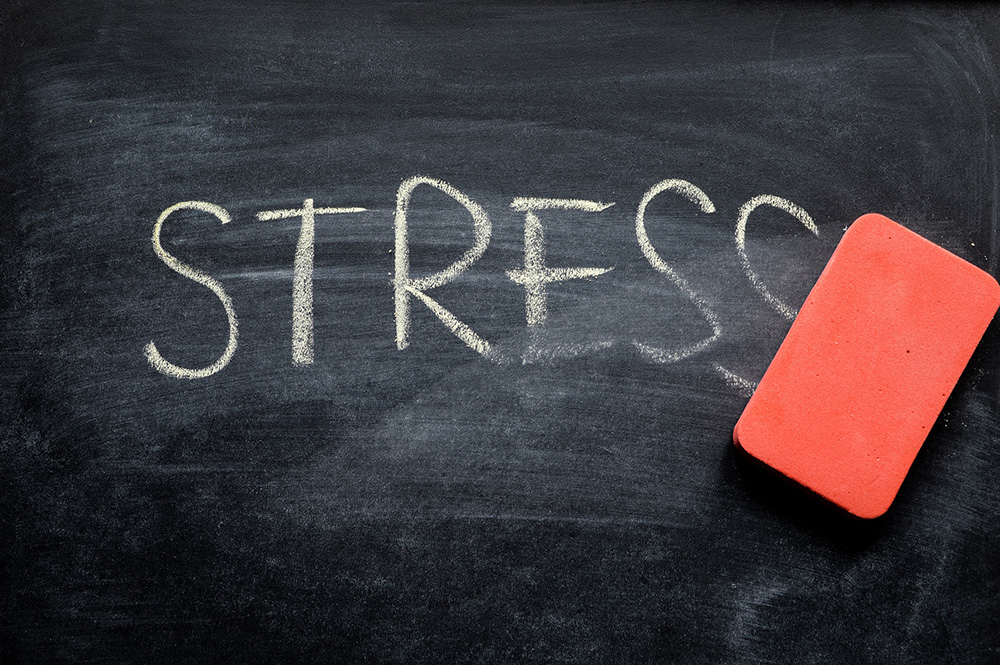 An eraser wiping off the word ‘stress’ on a chalkboard to represent the health benefits of walking.