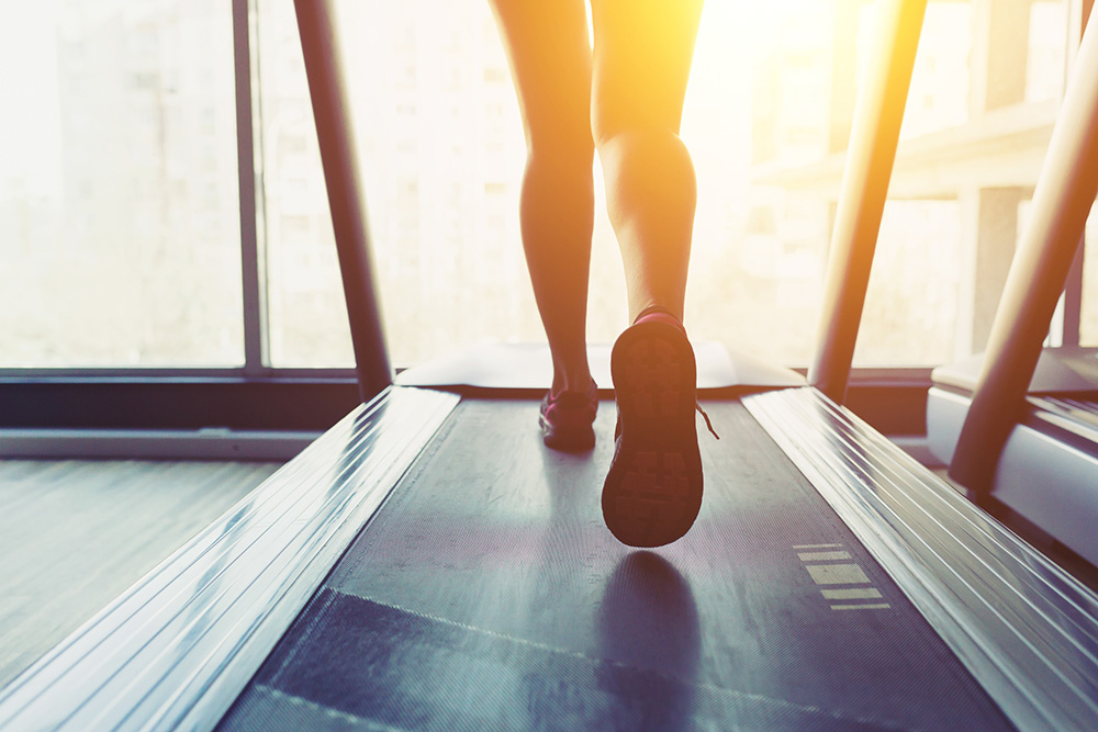 Close-up of person’s legs while walking on a treadmill.